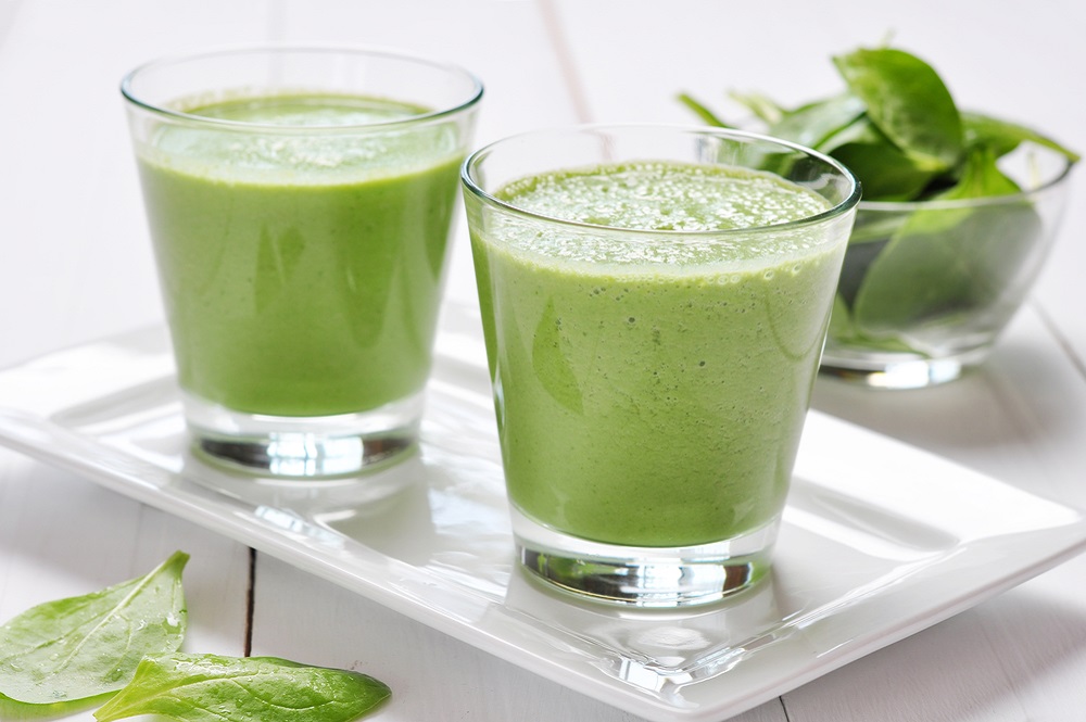 Two glasses of green smoothie on a plate